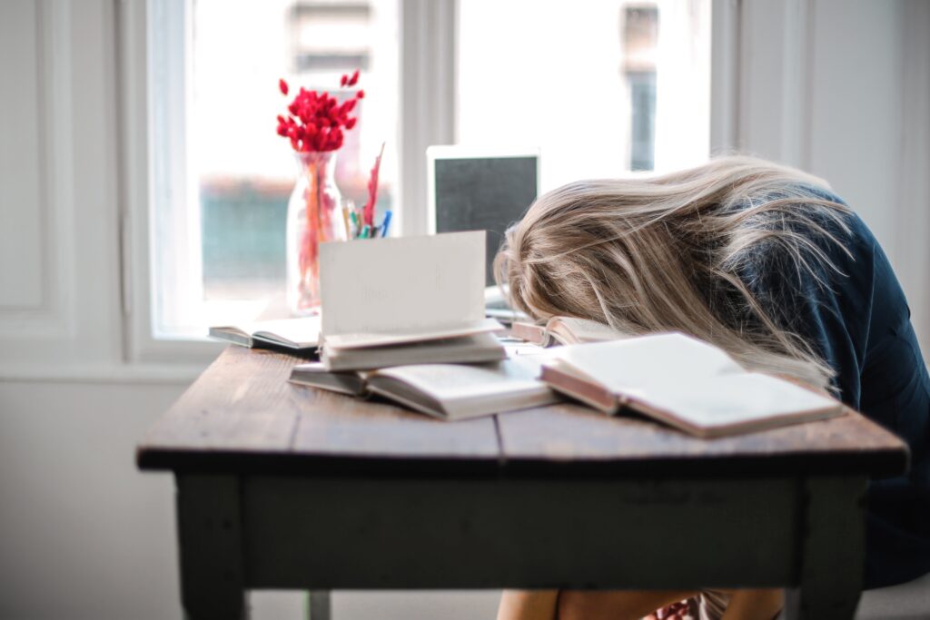 Lady with burnout, head on desk. Could you be suffering from Burnout?