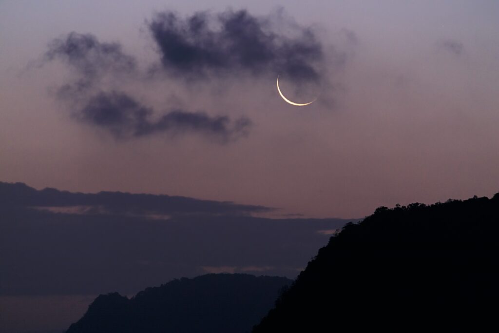 Crescent moon showing in the sky at the end of sunset. Could Living by the Moon Phases benefit you?